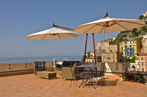 two umbrellas and a table and chairs on a balcony at La Zinefra Amalfi Dreams in Minori
