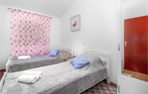 Donji Zagon的住宿－3 Bedroom Stunning Apartment In Novi Vinodolski，配有红色窗帘的客房内的两张单人床