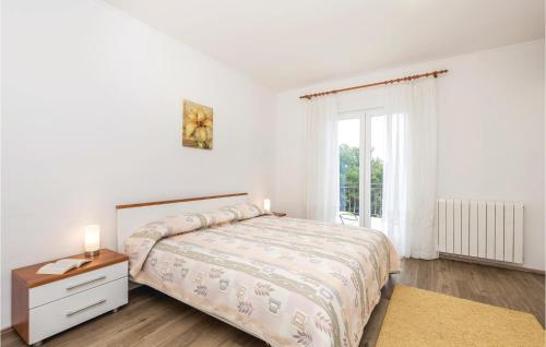 um quarto branco com uma cama e uma janela em Beautiful Apartment In Jurdani With Kitchen em Jurdani