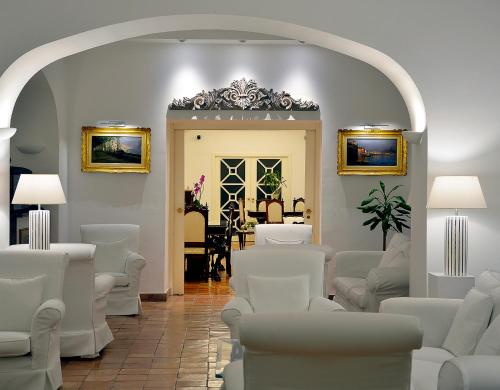 a waiting room with white chairs and a table at Villa Romana Hotel & Spa in Minori