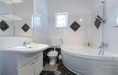 biała łazienka z wanną, toaletą i umywalką w obiekcie 2 Bedroom Lovely Apartment In Komarna w mieście Klek
