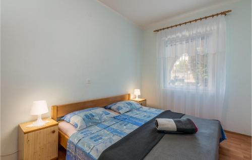 a bedroom with a bed and two lamps and a window at Beautiful Apartment In Pinezici With Wifi in Pinezici