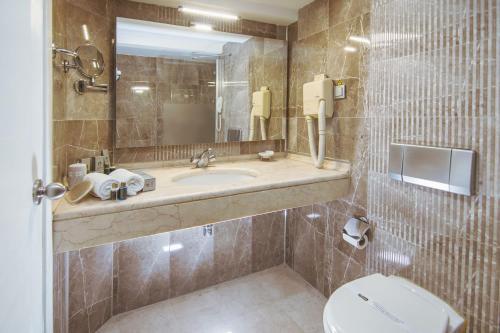 アンカラにあるAldino Hotel & Spaのバスルーム(洗面台、トイレ、鏡付)
