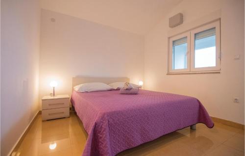 a bedroom with a bed with a purple blanket and a window at 1 Bedroom Awesome Apartment In Stari Grad in Stari Grad