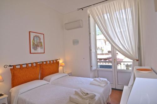 a bedroom with a bed and a large window at Braschi Amalfi Dreams in Minori