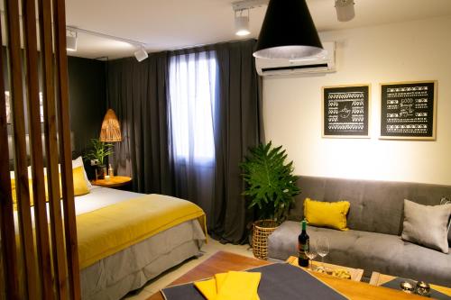 Habitación de hotel con cama y sofá en Studio Arístides en Mendoza