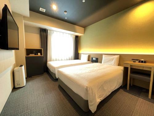 Henn na Hotel Kanazawa Korimbo tesisinde bir odada yatak veya yataklar