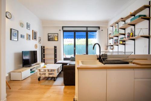 eine Küche mit einem Waschbecken und ein Wohnzimmer in der Unterkunft Apartment 5 minutes from the tram and 10 minutes from the sea in Nizza