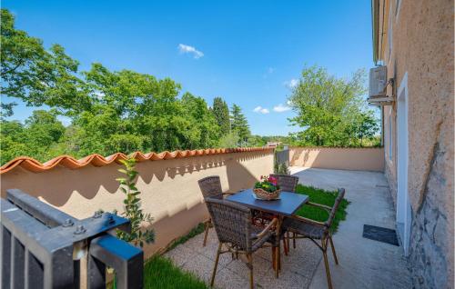 a patio with a table and chairs and a fence at One-Bedroom Apartment In Divsici in Divšići