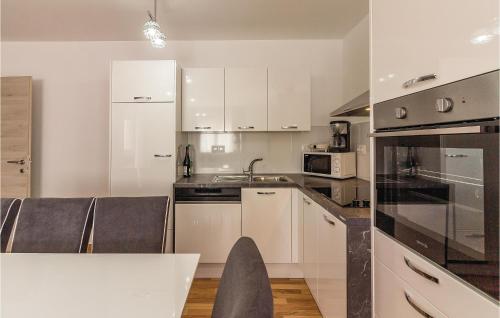 a kitchen with white cabinets and a sink at Three-Bedroom Apartment In Medulin in Medulin