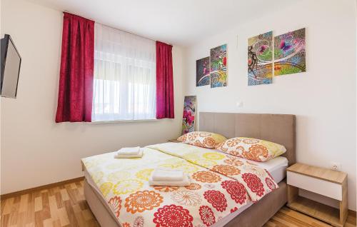 a bedroom with a bed and paintings on the wall at Three-Bedroom Apartment In Medulin in Medulin
