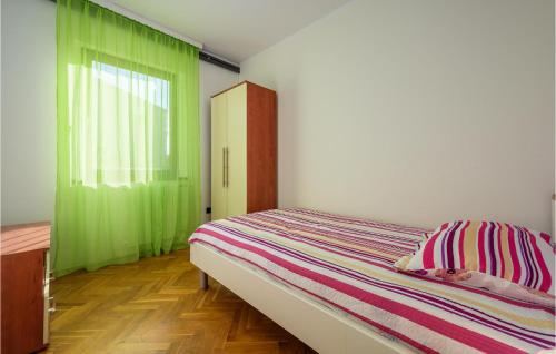a bedroom with a bed and a green curtain at 3 Bedroom Nice Apartment In Fazana in Fažana