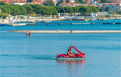 a person riding a red pedal boat in the water at Three-Bedroom Apartment In Medulin in Medulin