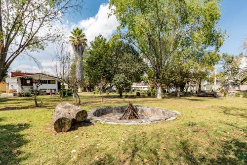a park with a fire pit in the grass at Ayenda Mesón del Río in Tepotzotlán