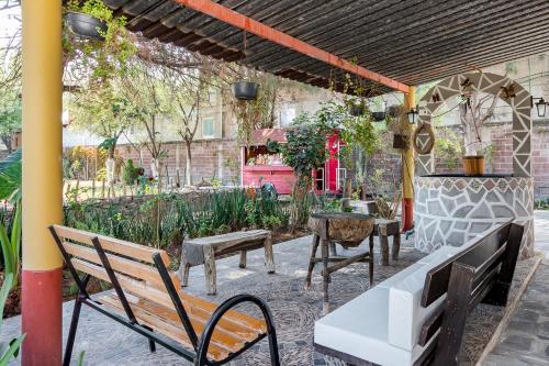 a patio with benches and tables and a building at Ayenda Mesón del Río in Tepotzotlán