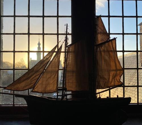 a boat sitting in front of a window at Auberge de Campveerse Toren in Veere