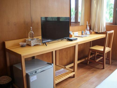 a wooden desk with a television on top of it at Natuna Dive Resort in Ranai