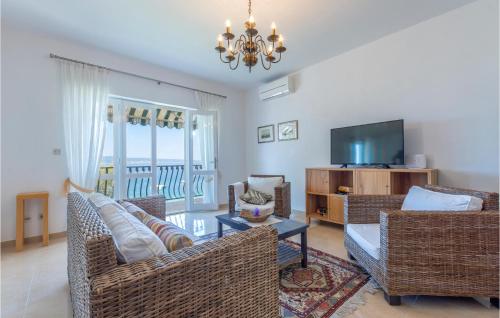 a living room with wicker furniture and a television at Pet Friendly Home In Dugi Rat With House Sea View in Dugi Rat