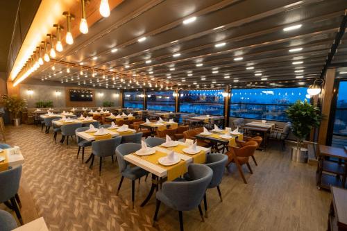 REF İNN HOTEL في أوردو: مطعم بطاولات وكراسي ونوافذ