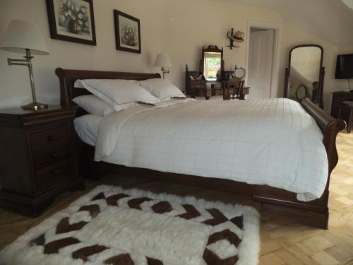 a bedroom with a large bed with a white comforter at Tabsfield in Eynsford