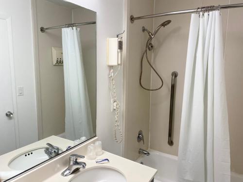 a bathroom with a shower and a sink and a mirror at Pilgrim Inn in Lee