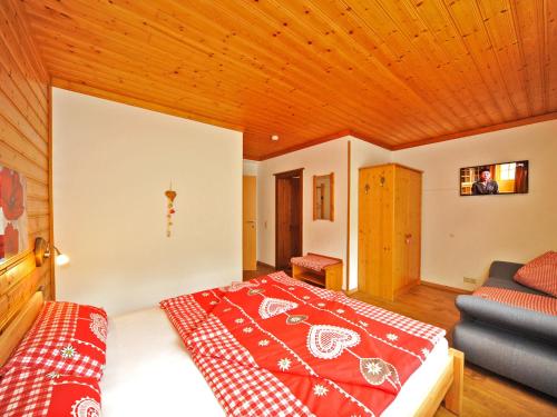a bedroom with a bed and a couch in a room at Haus Hasslacher in Flattach