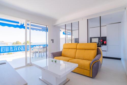 un salon avec un canapé jaune et une table dans l'établissement 1-Br Apartment Sea View Terrace & Parking, à Cannes