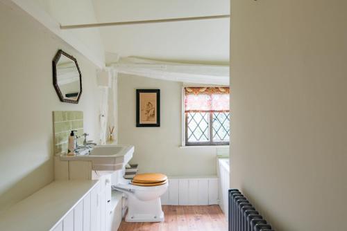 a white bathroom with a toilet and a sink at Bonnington Cottage by Bloom Stays in Canterbury