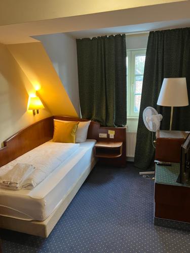 a bedroom with a bed and a window at Hotel am Schloss - Frankfurt an der Oder in Frankfurt/Oder