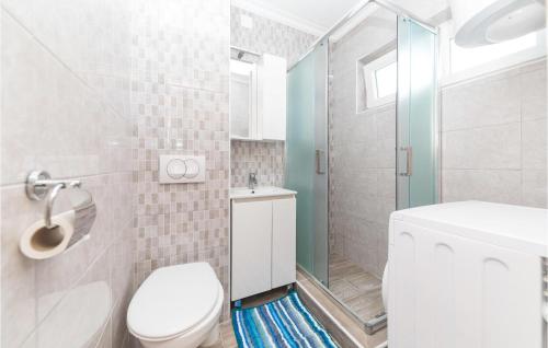 La salle de bains blanche est pourvue d'une douche et de toilettes. dans l'établissement Nice Apartment In Okrug Gornji With Wifi, à Trogir