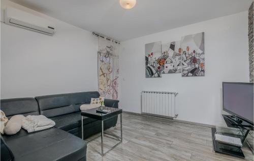 salon z kanapą i telewizorem w obiekcie Cozy Apartment In Vrbnik w mieście Vrbnik