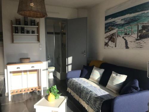- un salon avec un lit et un canapé bleu dans l'établissement Perle d’horizon marin, à Sète