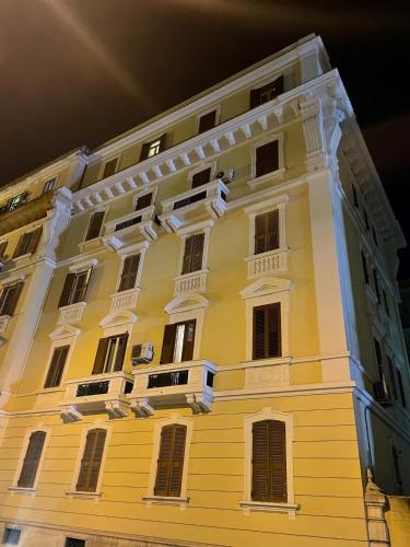ein großes gelbes Gebäude mit Seitenfenstern in der Unterkunft Blue & Grey downtown Foggia in Foggia