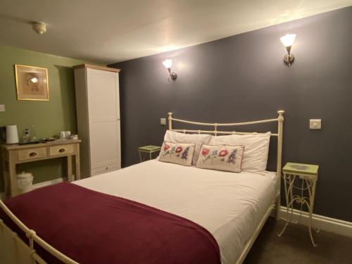 sypialnia z łóżkiem z białą pościelą i poduszkami w obiekcie The Carriers Arms w mieście Codford Saint Mary