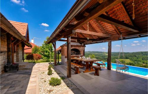 an outdoor patio with a table and a pool at Gorgeous Home In Martinkovec With Sauna in Jarki Horvatićevi