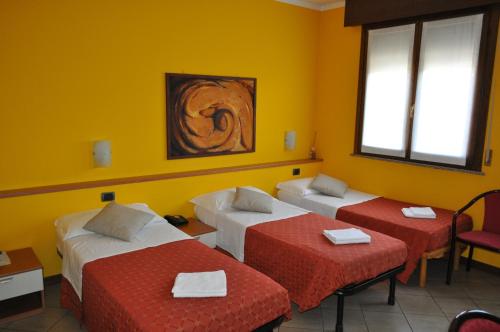 a room with two beds and a table and chairs at Hotel Mantova Sud in Bagnolo San Vito