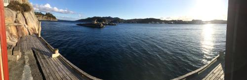 a view of a body of water with a fence at Bergen/Sotra:Waterfront cabin(s).Boat.Fish.Jacuzzi in Haganes