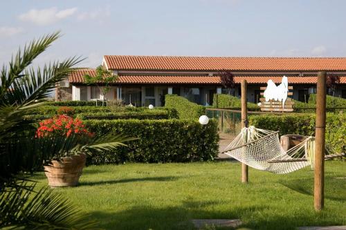 a hammock in a yard in front of a house at Fattoria Maremmana in Marina di Grosseto