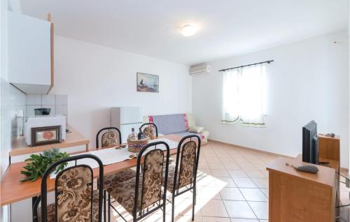 a kitchen and living room with a table and chairs at Amazing Apartment In Vidalici With Wifi in Kustići