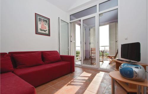 un salon avec un canapé rouge et une télévision dans l'établissement Apartment Vodnjan Peroj Iii, à Vodnjan