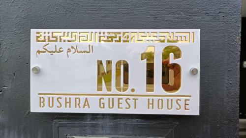 a sign for a guest house on a wall at Homestay Batu Pahat, BUSHRA in Batu Pahat