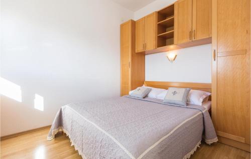 1 dormitorio con 1 cama y armario de madera en Nice Apartment In Makarska With 1 Bedrooms And Wifi en Makarska