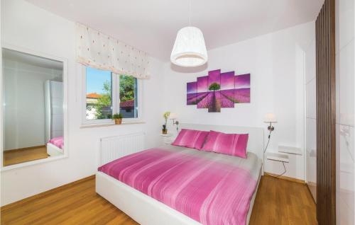 a white bedroom with a pink bed and a window at 1 Bedroom Stunning Apartment In Kastel Gomilica in Kaštela