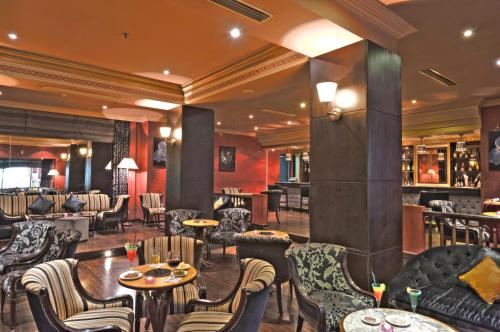 a restaurant with tables and chairs and a bar at Kennedy Hospitality Resort in Marrakech