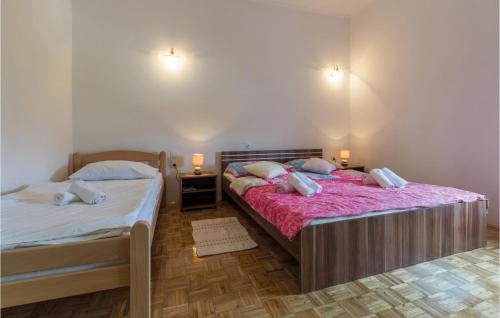 two beds in a bedroom with two lamps on the wall at 2 Bedroom Stunning Apartment In Porec in Dračevac
