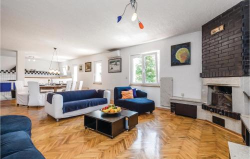 un salon avec un canapé bleu et une cheminée dans l'établissement 4 Bedroom Gorgeous Home In Jurdani, à Jurdani