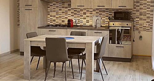 a kitchen with a white table and chairs in it at LA CASA DI FRANCESCO in Putifigari
