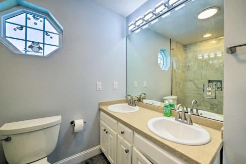 a bathroom with two sinks and a toilet and a mirror at Updated and Sunny PCB Home Steps to the Beach! in Panama City Beach