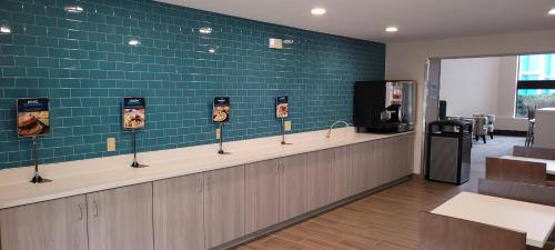 a waiting room with green tile on the wall at Clarion Pointe OKC Airport in Oklahoma City
