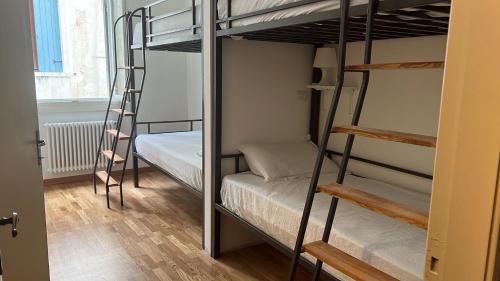 a room with two bunk beds and a ladder at Foresteria Sociale San Marco Venice in Venice